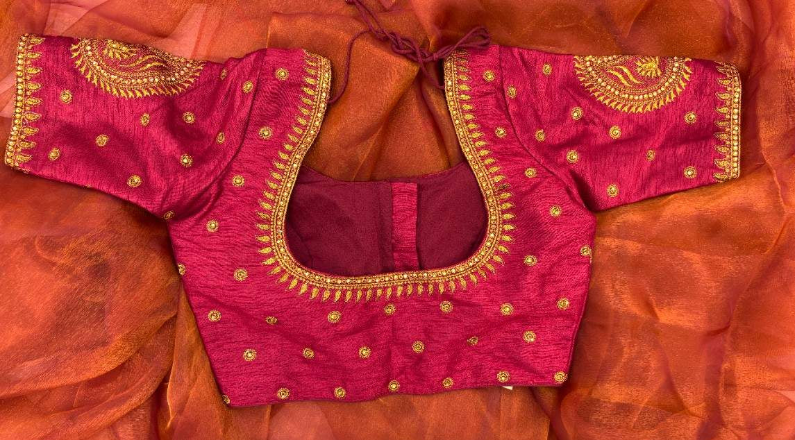 Back view of Sitara Paisley Blouse highlighting the dori tie-up and smooth maroon silk surface. The back maintains a clean, elegant look with subtle sheen, balancing the ornate sleeves featuring paisley motifs crafted in gold thread and tiny stone embellishments