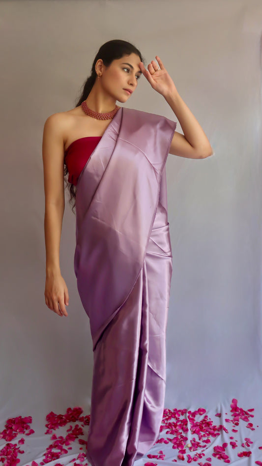 A woman standing with mauve purple saree