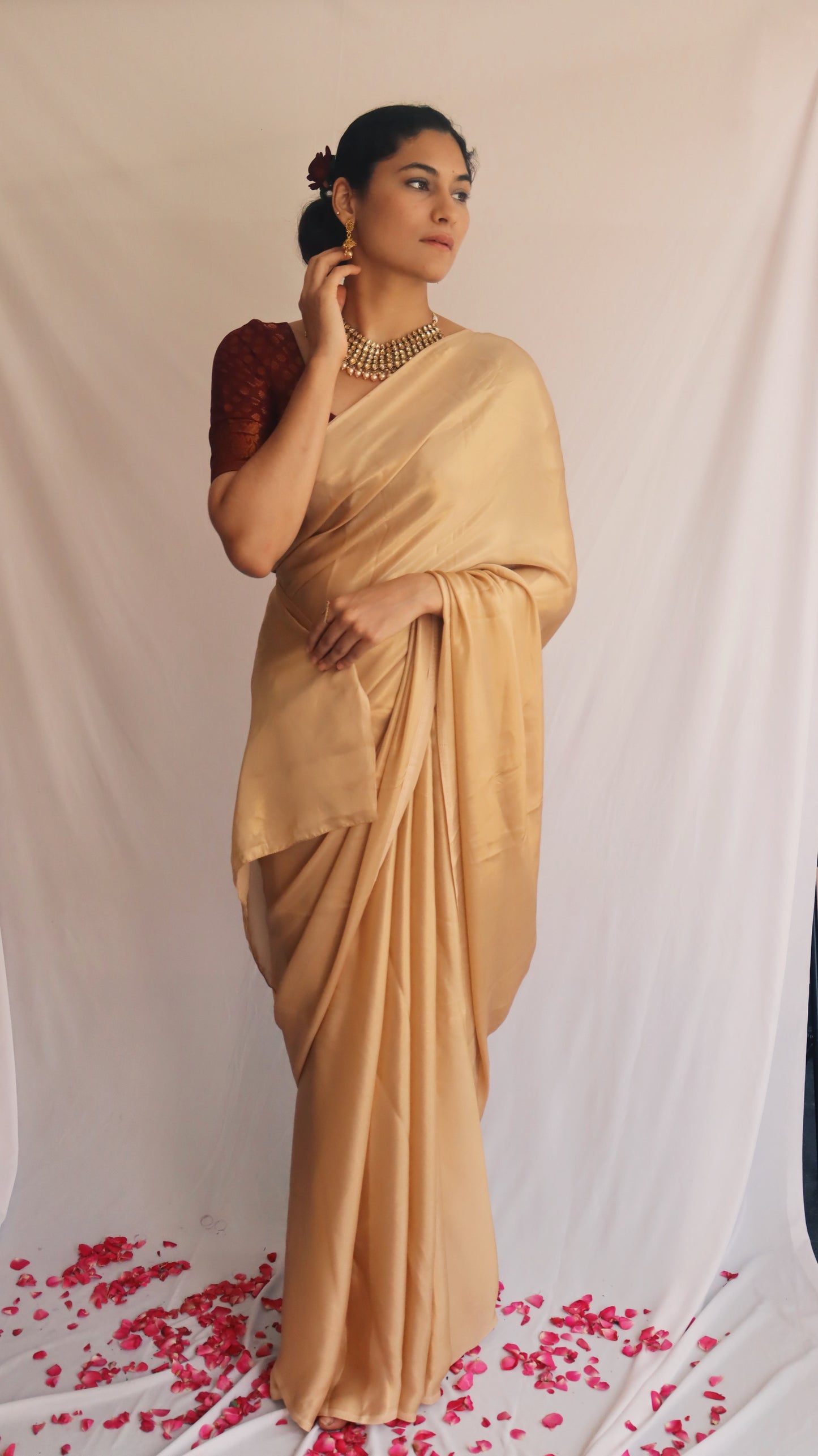 A model gracefully wearing the Gold Shimmer Saree, demonstrating its elegant drape in a festive setting.