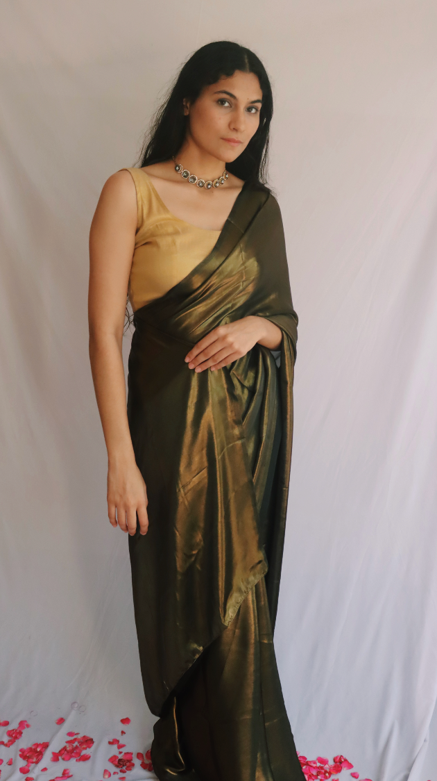 A model wearing and showing the beautiful shine of the black and gold shimmer saree.
