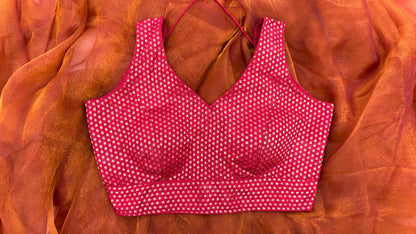 Front view of Label Anaira’s Mango Bloom Red Blouse — deep red sleeveless blouse featuring intricate gold mango (paisley) motifs. Perfect for pairing with festive or wedding sarees, this blouse combines traditional craftsmanship with modern elegance.