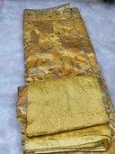 Folded marigold aurielle fabric with floral patterns on a gray background