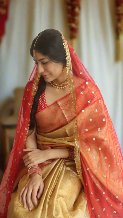 A woman, Gracefully draped in the Gold Tissue Wedding Saree, demonstrating its elegant drape at a wedding event.