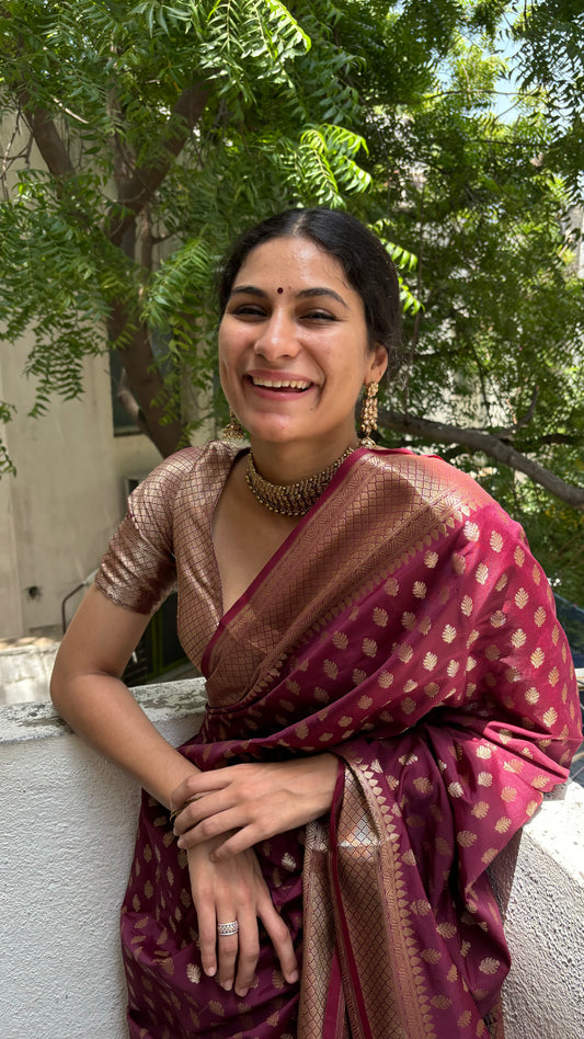 The Classic Plum Maroon Banarasi Saree elegantly draped, showcasing its rich color and intricate patterns, ideal for weddings and festive celebrations