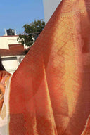 Close-up of a textured gold threading on fabric with a pattern, blurred background