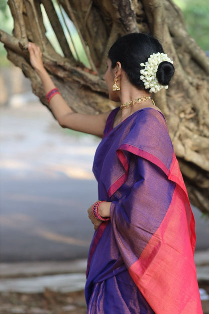 Woman wearing flowers styling Purple cotton tissue saree with pink pallu so gracefully