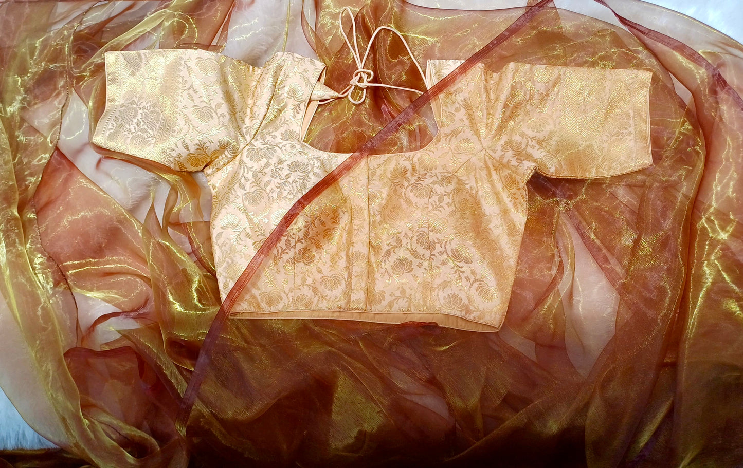 Cream brocade blouse with amber shaded organza saree