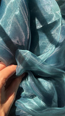 Close-up of dark blue fabric with a hand touching it