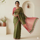 Model wearing dark green and pink linen tissue saree for festive occasions