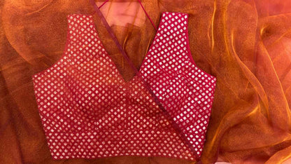 Front view of Label Anaira’s Crimson Diamond Blouse, a deep red brocade blouse adorned with intricate silver diamond (paisley) motifs. The sleeveless V-neck design offers elegance and comfort, making it perfect for pairing with festive and wedding sarees, while showcasing premium Indian craftsmanship