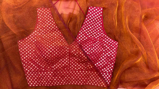 Front view of Label Anaira’s Crimson Diamond Blouse, a deep red brocade blouse adorned with intricate silver diamond (paisley) motifs. The sleeveless V-neck design offers elegance and comfort, making it perfect for pairing with festive and wedding sarees, while showcasing premium Indian craftsmanship
