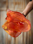 Orange fabric held by a person against a blurred background