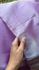 Hand touching Lavender Silver Organza Saree with a blurred background