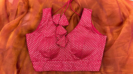 Detailed close-up of deep red silk blend fabric of the Mango Bloom Red Blouse highlighting delicate gold mango (paisley) motifs. Rich texture and subtle shine make it ideal for festive or wedding sarees.