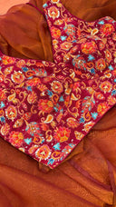 Side view of Anaira Rang Mahal Blouse highlighting the rich maroon crepe fabric and elaborate multicolored floral embroidery. Sleeveless design ensures comfort and versatility while adding a festive, luxurious touch.