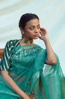 Teal Organza Saree with a white pattern, sitting against a light background.