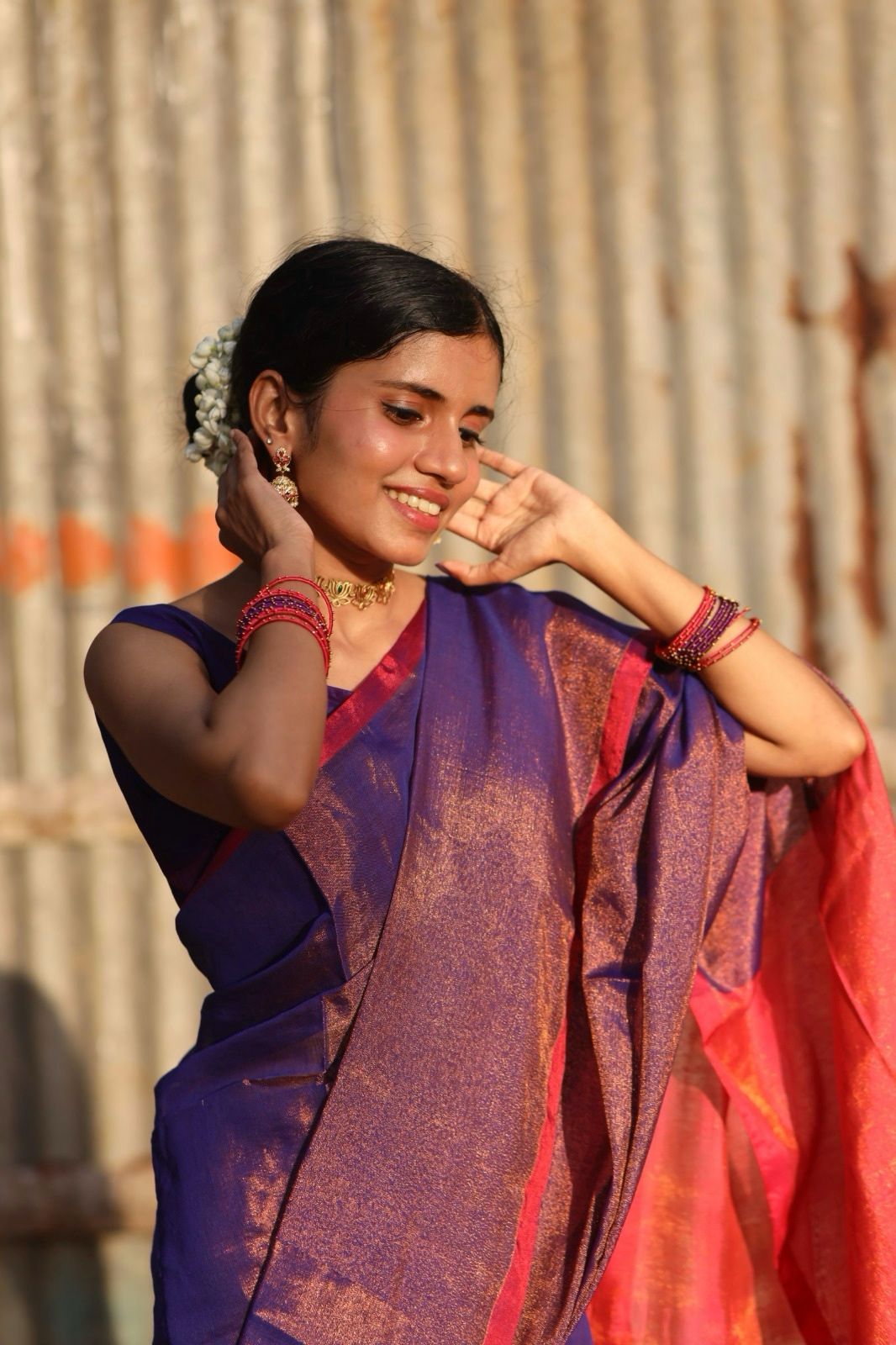 Model wearing Purple cotton tissue saree with Pink pallu shining under sunlight 