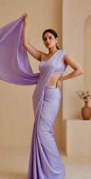Woman wearing a lavender saree with a plain background