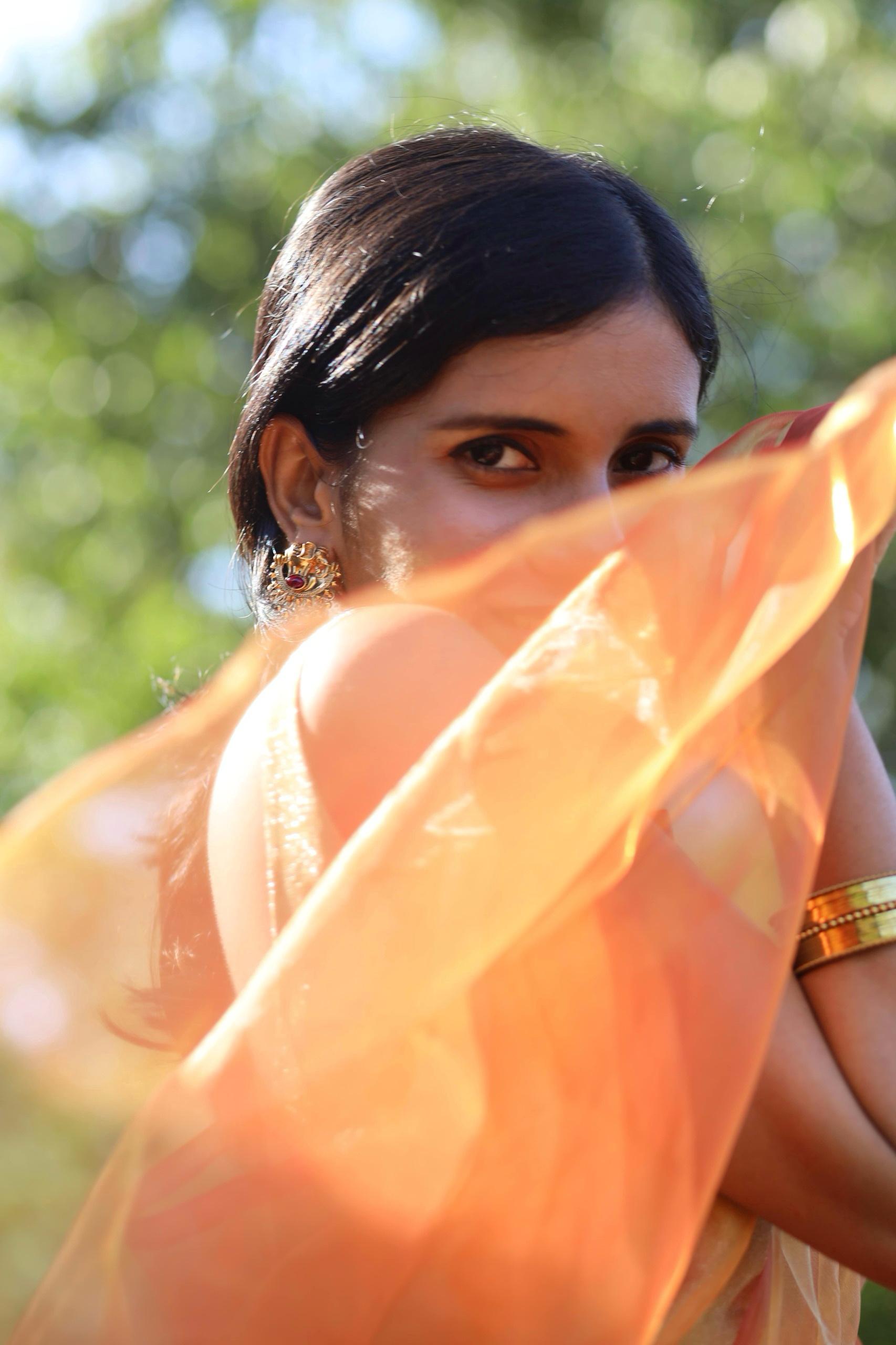 Orange gold organza saree flowing beautifully 