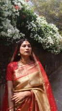 Woman in Molten Gold Tissue Saree standing in front of white flowers