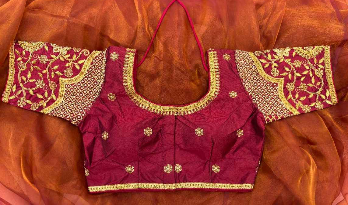 Front view of Label Anaira’s Noor-e-ZariBlouse, a deep maroon silk blend blouse with heavy golden Aari/Maggam embroidery. Features floral and paisley motifs on sleeves, dense geometric patterns on the body, and thick embellished borders at the neckline, perfect for weddings and festive occasions