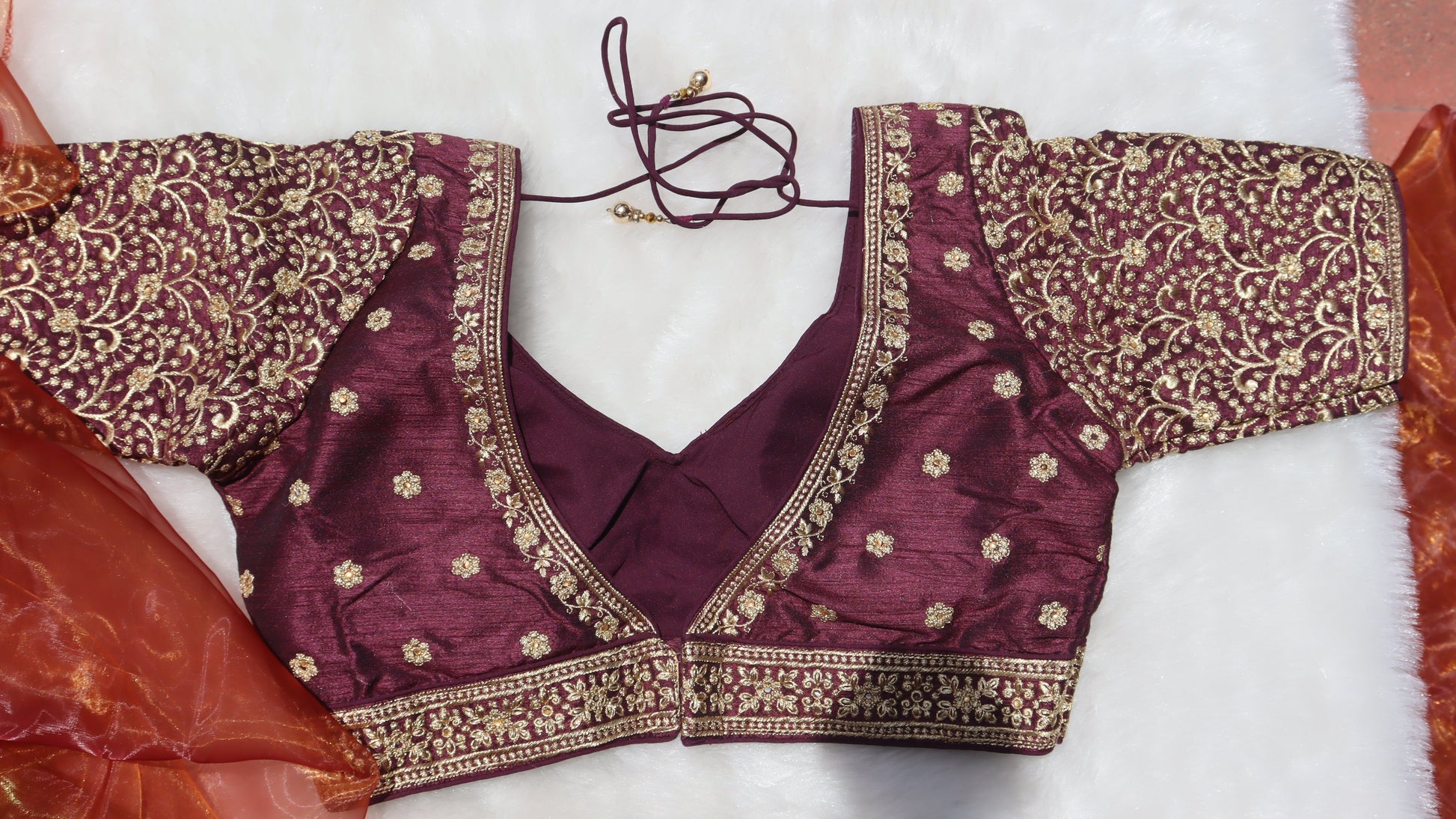 Image showing the back of a traditional brown blouse with gold thread work