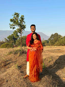 Couple standing in a field with woman in honey vine organza saree