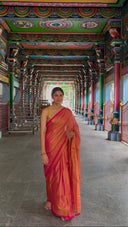 Woman in Pink Pink Pink Tissue Sareestanding in a temple corridor with colorful ceiling