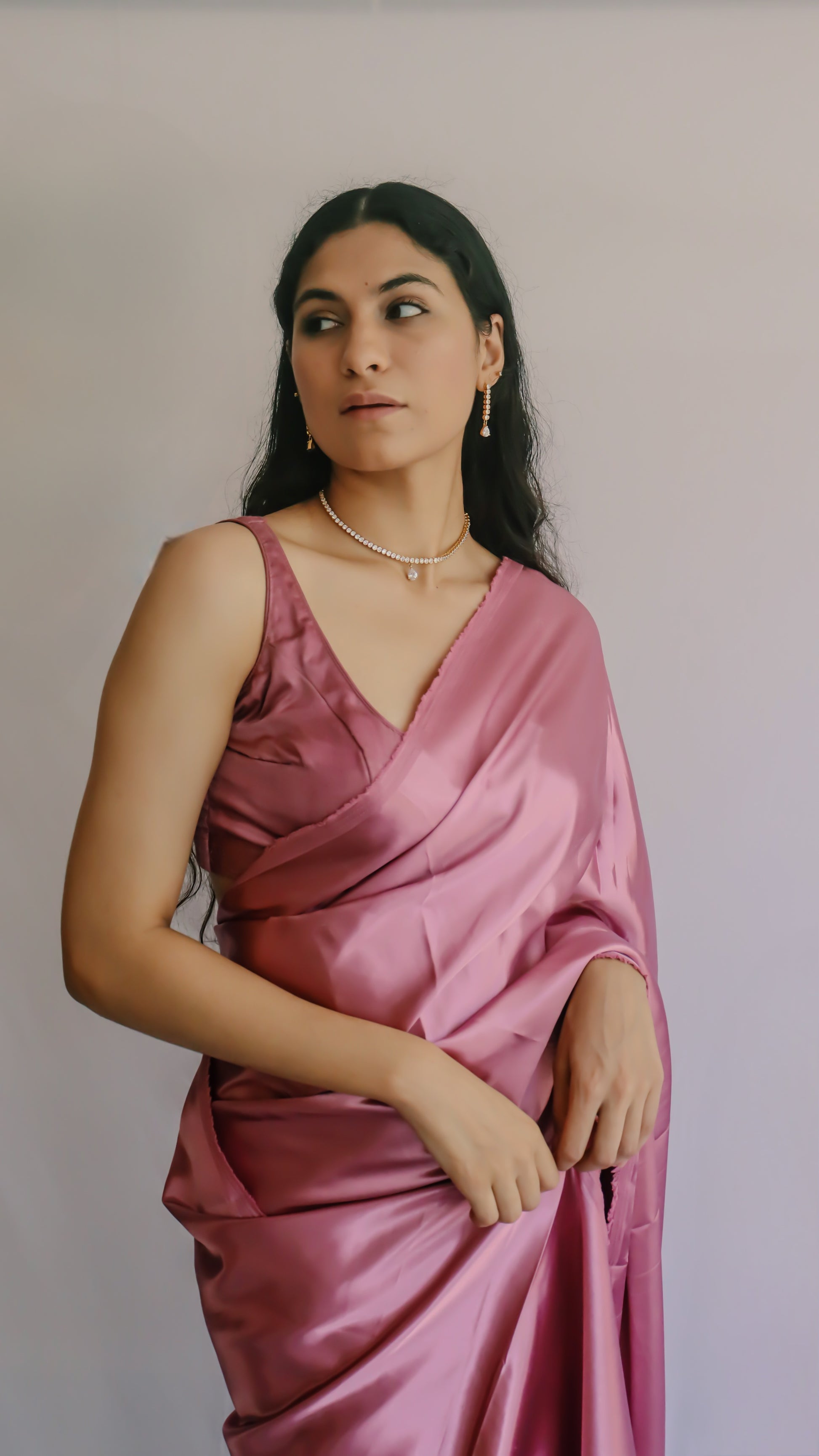 A woman wearing a dusty pink satin saree