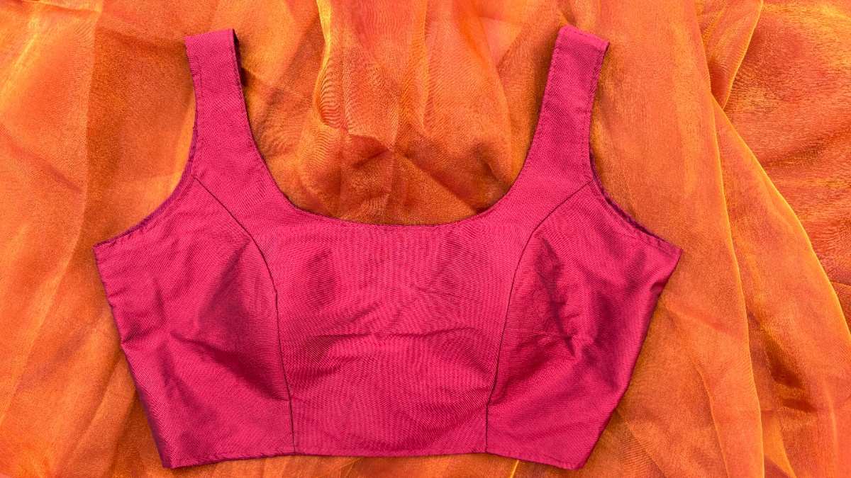 Plain maroon sleeveless blouse made from soft silk blend fabric. The blouse has a clean, elegant neckline and fits perfectly for festive sarees or daily wear looks.