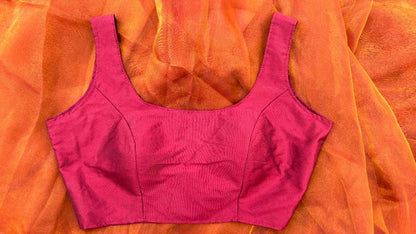 Plain maroon sleeveless blouse made from soft silk blend fabric. The blouse has a clean, elegant neckline and fits perfectly for festive sarees or daily wear looks.