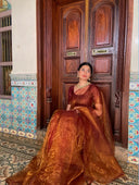 Shriya in Queen Bee sitting in front of a wooden door with decorative tiles.