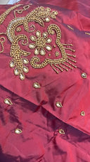 Red fabric with gold embroidery on a white background