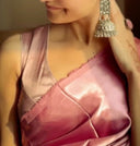Close-up of a person wearing pink satin saree