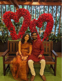 Couple sitting on a bench with woman wearing honey organza saree