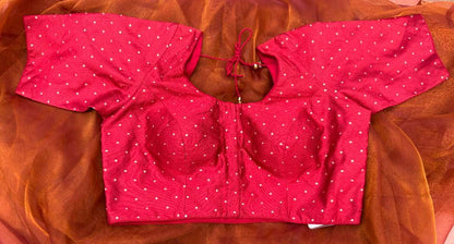 Front view of Label Anaira’s Sindoor Gold Polka Blouse, a rich sindoor red blouse adorned with shimmering gold polka embroidery. Sleeveless design with dori tie-up back, perfect for festive occasions and wedding saree ensembles, highlighting traditional yet contemporary craftsmanship