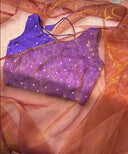 Purple sparkly top on a draped fabric background