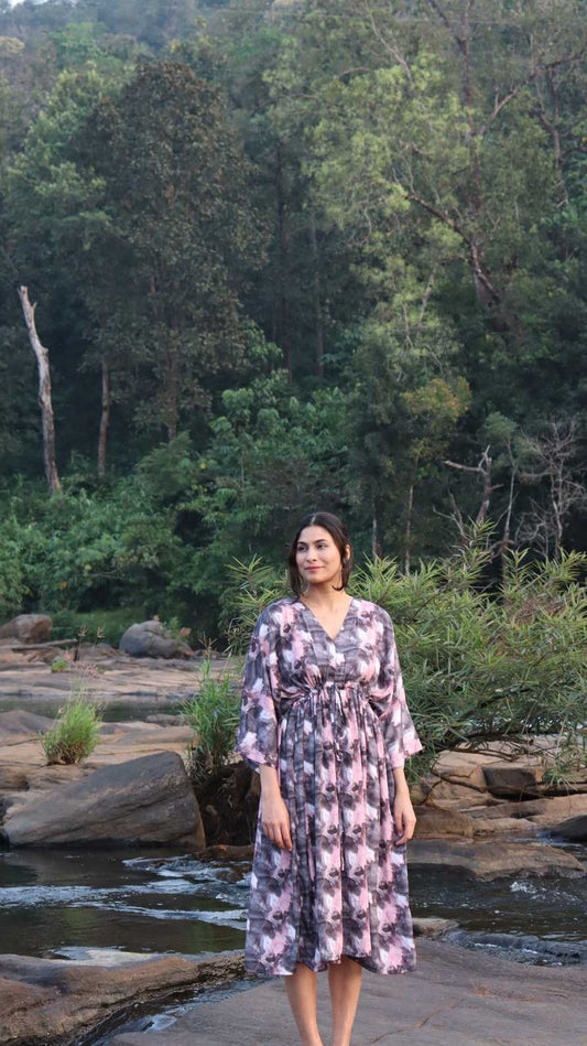 Woman wearing a twilight marble free size crepe dress with pockets, standing outdoors near a stream