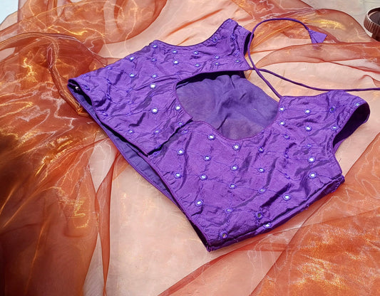 The back of a violet blouse with mirror work and ties 