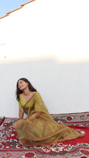 Front view of A Secret in the Garden Olive Organza Saree by Label Anaira, a lightweight sheer olive green organza saree perfect for weddings and festive occasions.