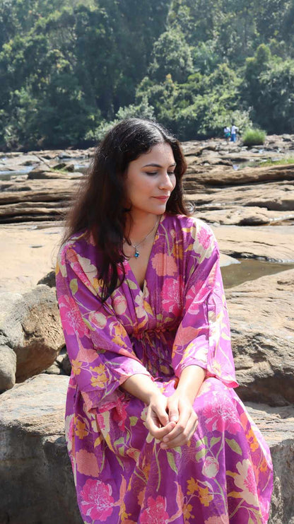 Seated front view of purple floral crepe dress with relaxed silhouette