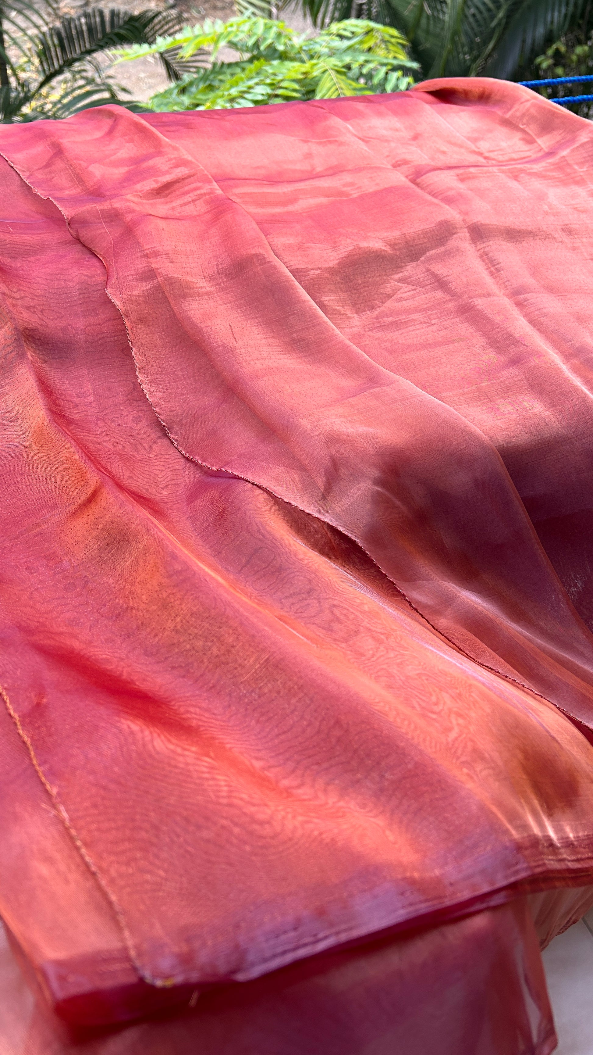 an image showing red maroon orange pink and gold shade organza saree