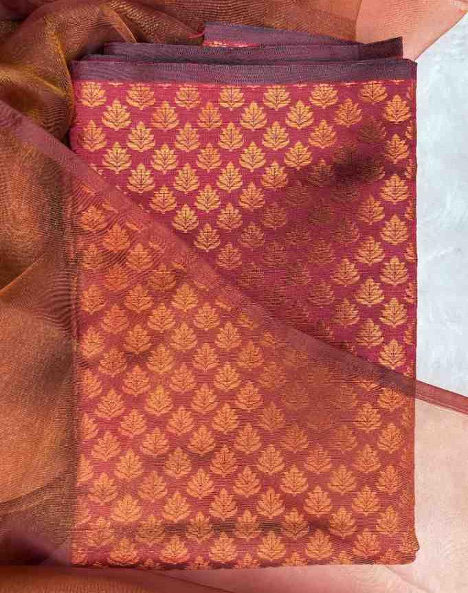 Folded fabric with a gold leaf pattern on a maroon background - anaira blouse - maroon leaf pattern blouse material 
