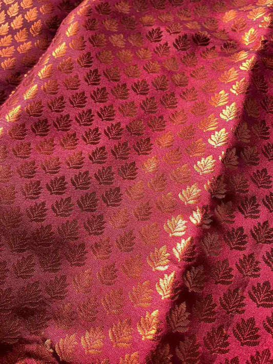 Close-up of maroon blouse material with gold leaf pattern on maroon material