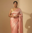 Woman in a traditional look wearing Blushing Bride Pink Satin Silk Saree with gold shimmer, beige backdrop — Label Anaira
