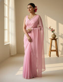 Light pink organza saree Blushy Blush worn by model in a softly lit studio, showcasing sheer drape and elegant fall