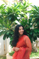 Woman smiling in Queen Bee Honey Organza Saree against greenery — gold and brown festive saree, Label Anaira