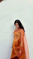 Portrait view of The Sunset Debutante saffron organza saree by Label Anaira showcasing radiant saffron fabric and elegant sheer drape.