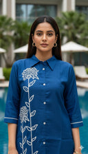 Close-up of wildflower embroidery and pearl-look buttons on teal kurta