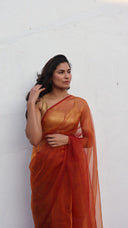Portrait view of the Whispers by Candlelight ember organza saree by Label Anaira showcasing glowing copper orange fabric and elegant sheer drape.